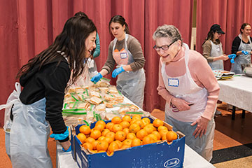 Two women laugh as they prepare a food table for an event together. Links to Gifts of Cash, Checks, and Credit Cards Two women laugh as they prepare a food table for an event together. Links to Gifts of Cash, Checks, and Credit Cards