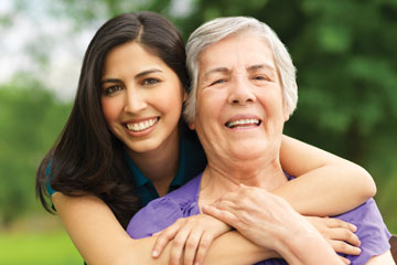 A woman hugging her grandmother from behind. Links to Gifts of Real Estate A woman hugging her grandmother from behind. Links to Gifts of Real Estate