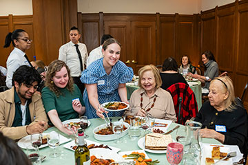 A table of people grin as a volunteer brings food to the table. Links to Closely Held Business Stock A table of people grin as a volunteer brings food to the table. Links to Closely Held Business Stock